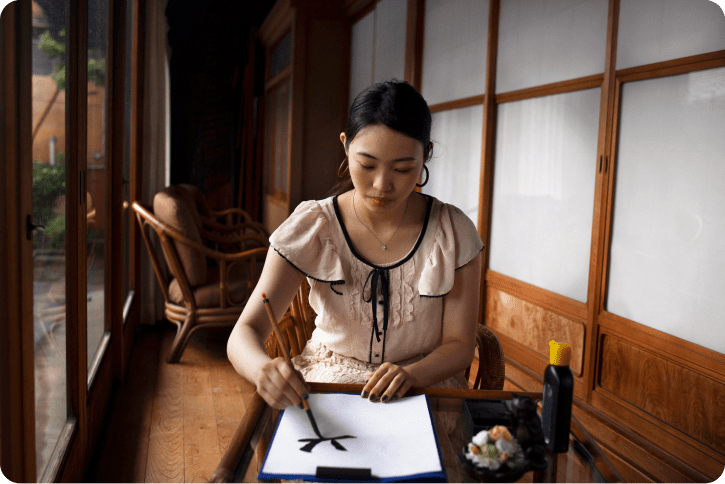 asian-woman-practicing-japanese-handwriting-indoors 1-min